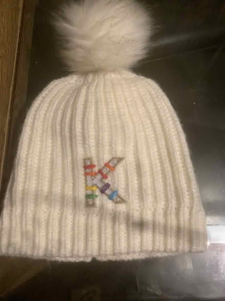 Photo of free White bobble hat with K (Benhall GL51) #1