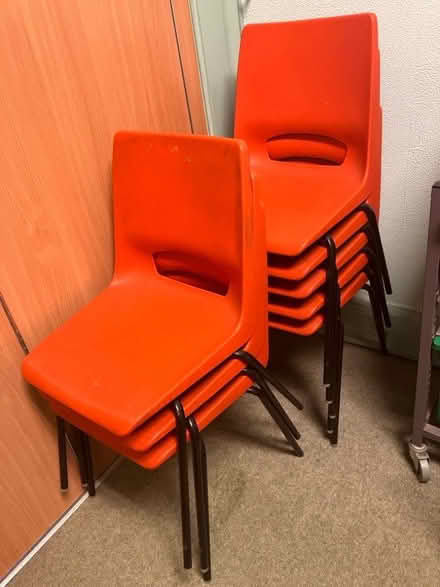 Photo of free 8 orange stacking plastic chairs (Bow E3) #1